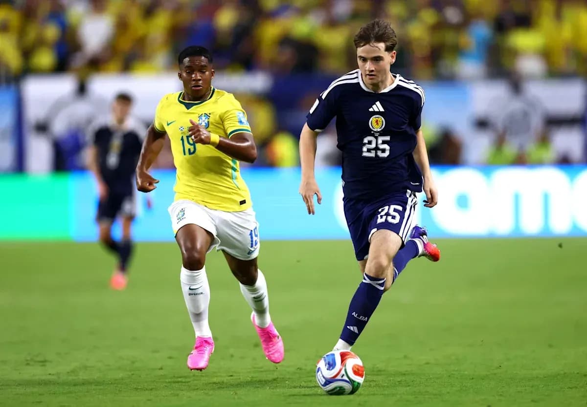Player in blue jersey dribbling ball, pursued by opponent Player in blue jersey dribbling ball, pursued by opponent