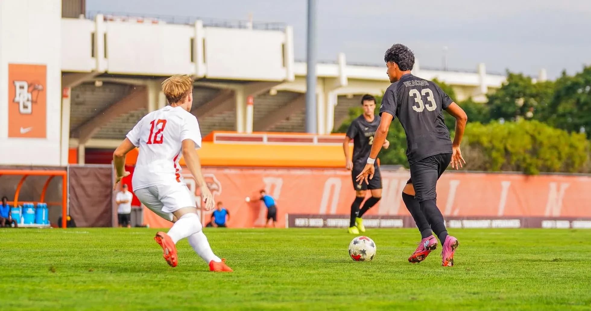 Player in black dribbling ball against opponent in white Player in black dribbling ball against opponent in white