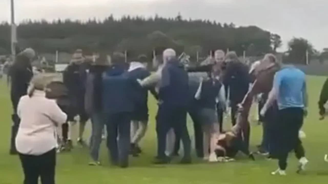 Crowd gathering around a fallen player on field Crowd gathering around a fallen player on field