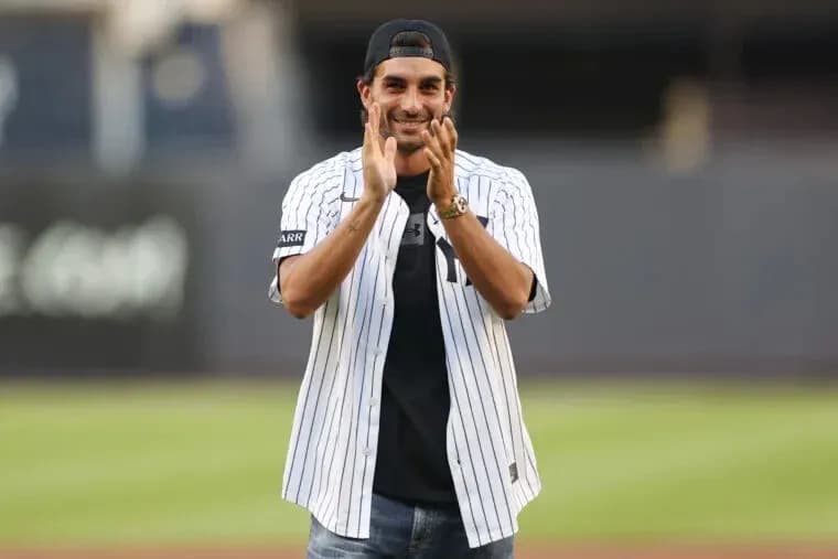 Man in Yankees jersey applauding at baseball field Man in Yankees jersey applauding at baseball field