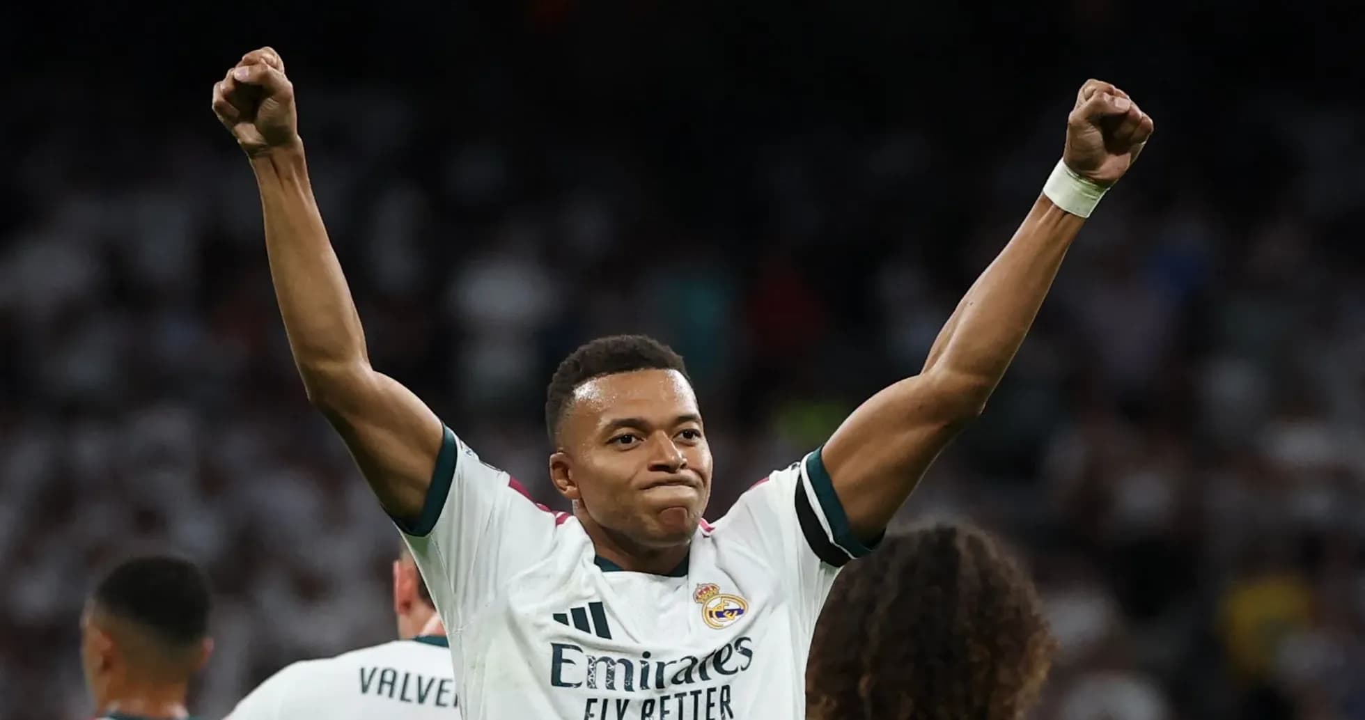 Player celebrating victory with raised arms in stadium Player celebrating victory with raised arms in stadium