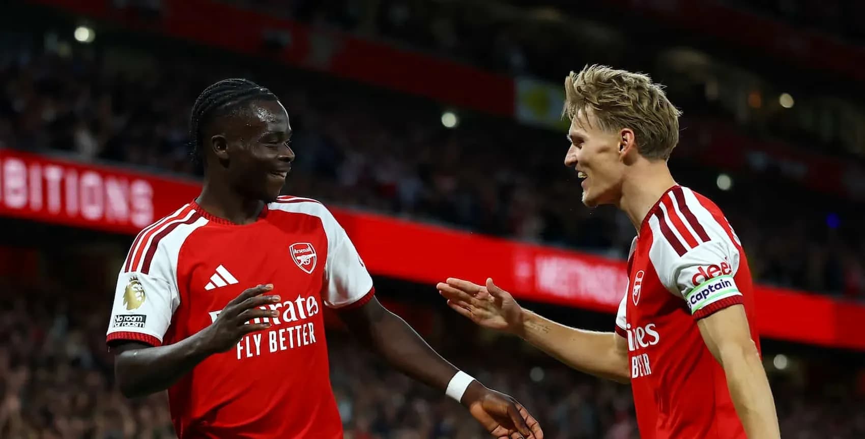 Two Arsenal players celebrating during a match Two Arsenal players celebrating during a match