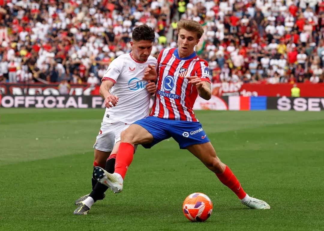 Sevilla player tackles Atletico Madrid opponent Sevilla player tackles Atletico Madrid opponent