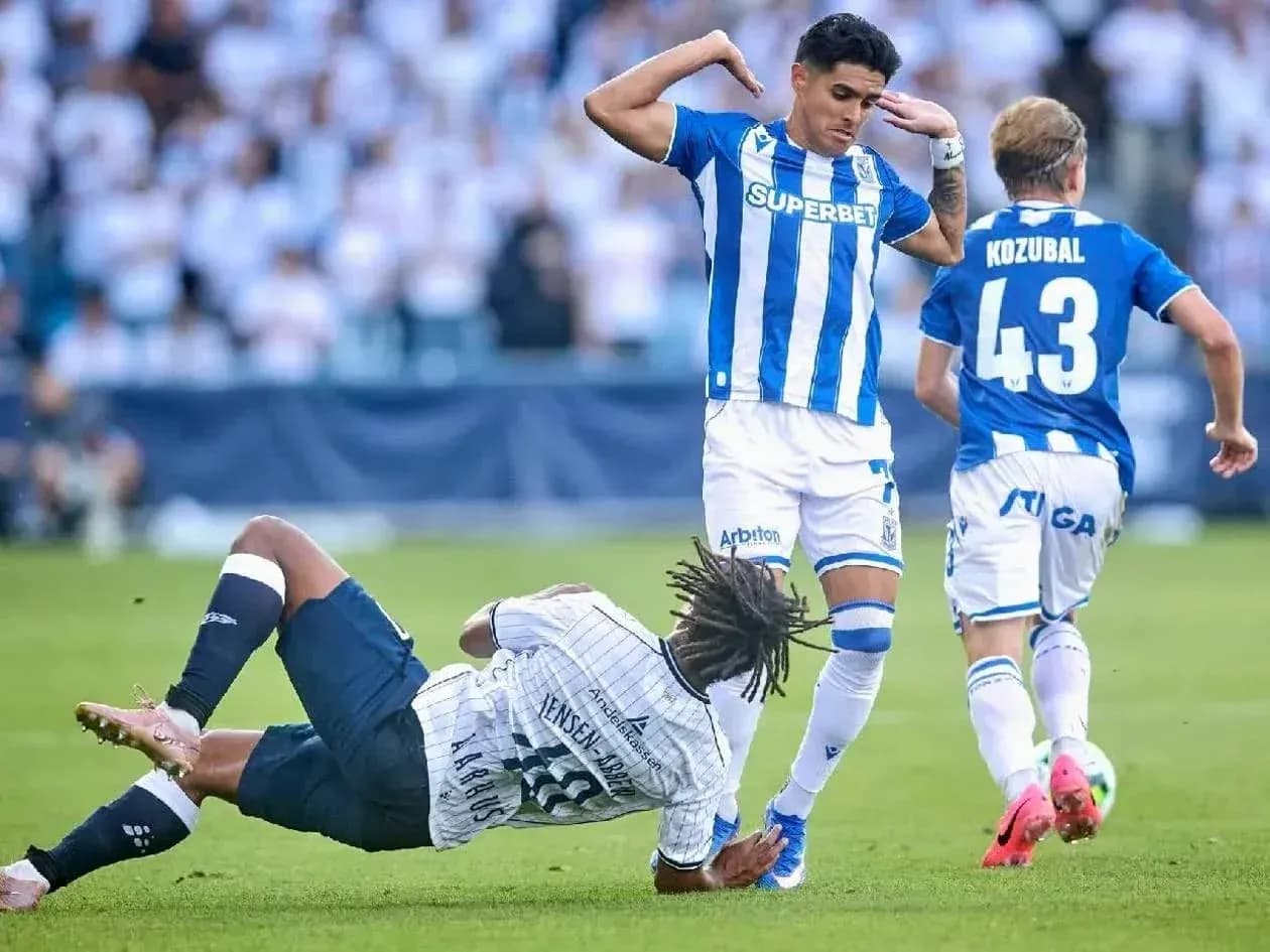 Lech Poznan player avoiding Aarhus tackle Lech Poznan player avoiding Aarhus tackle