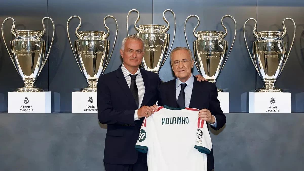 Mourinho holding a jersey with trophies in background Mourinho holding a jersey with trophies in background