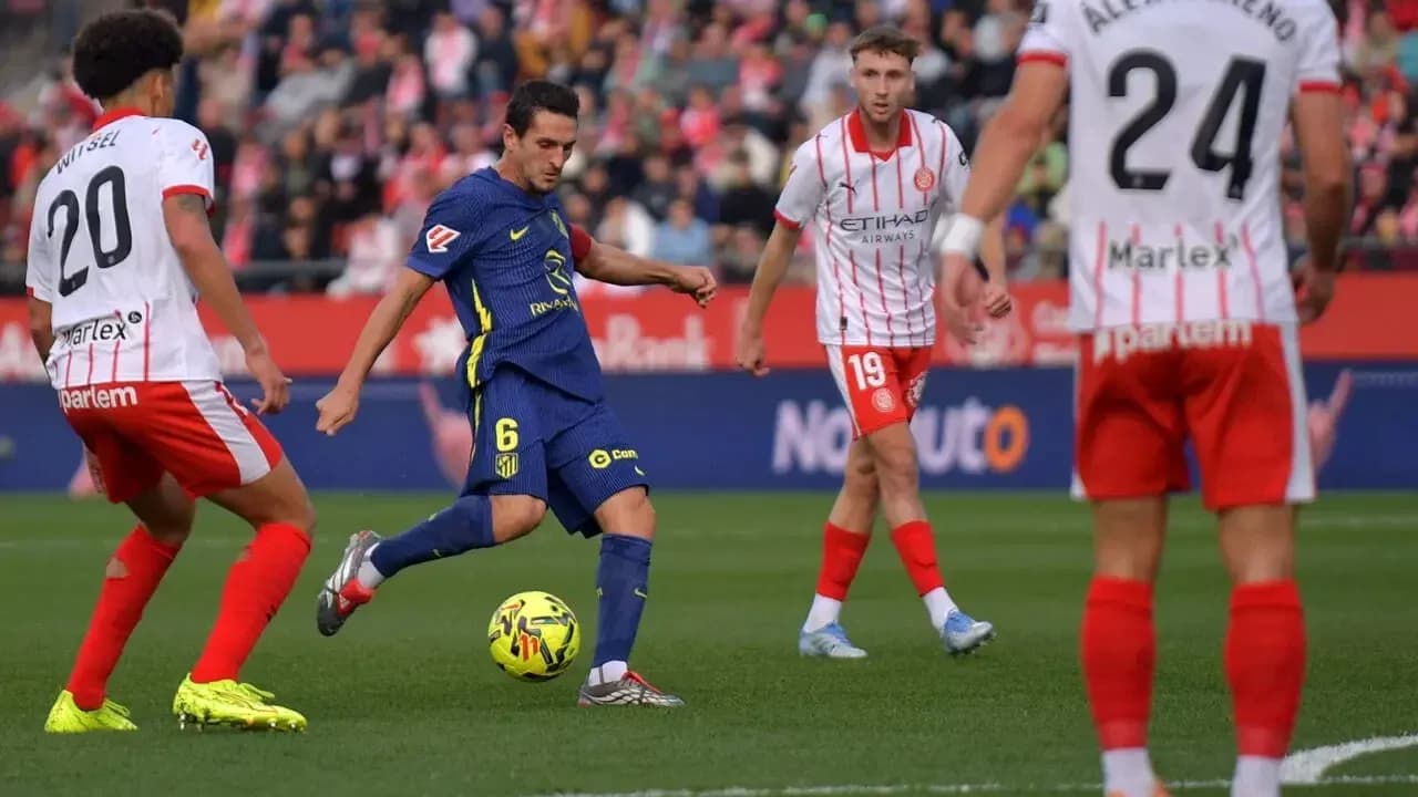 Atletico Madrid player passing the ball against Girona Atletico Madrid player passing the ball against Girona