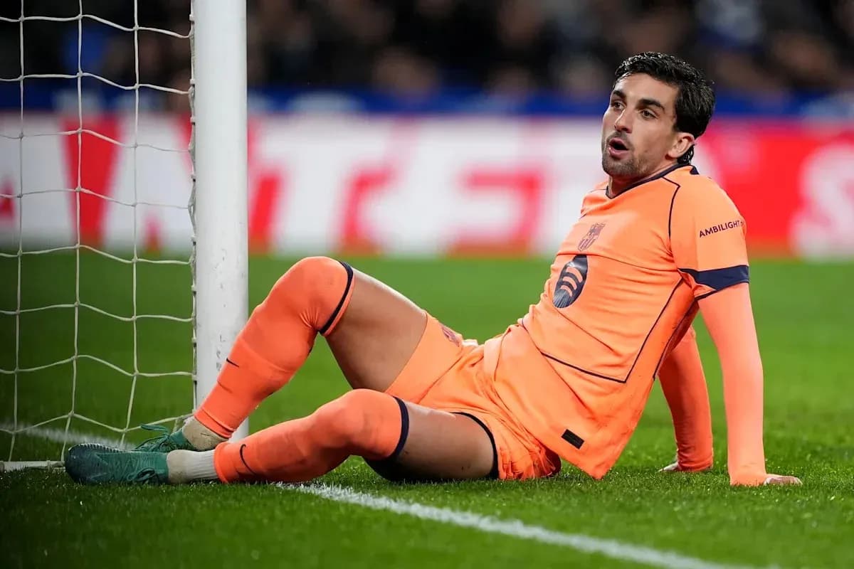 Goalkeeper sitting on the pitch near goalpost Goalkeeper sitting on the pitch near goalpost