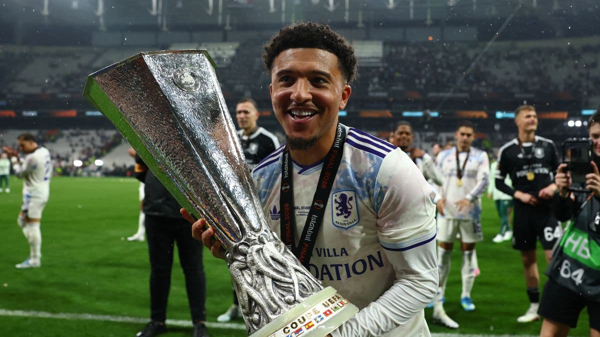 Player celebrating with UEFA trophy on the field Player celebrating with UEFA trophy on the field