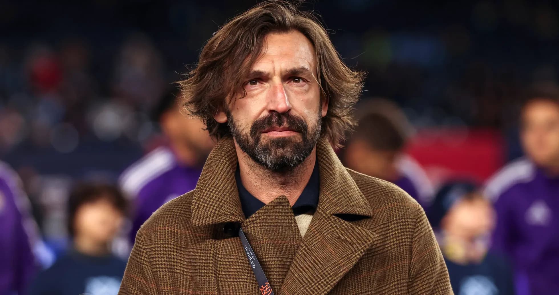 Coach in brown coat at a match event Coach in brown coat at a match event