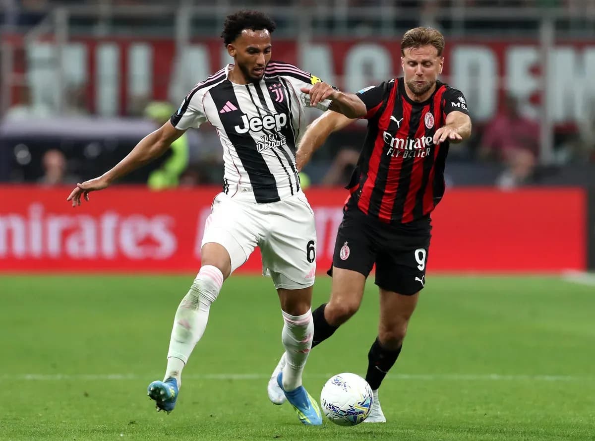 Juventus player challenged by AC Milan opponent Juventus player challenged by AC Milan opponent