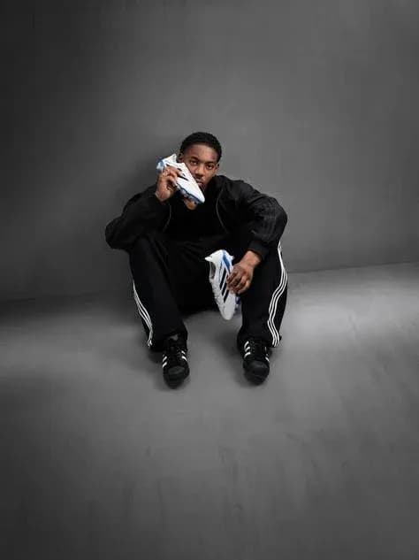 Athlete sitting on floor holding soccer shoe Athlete sitting on floor holding soccer shoe