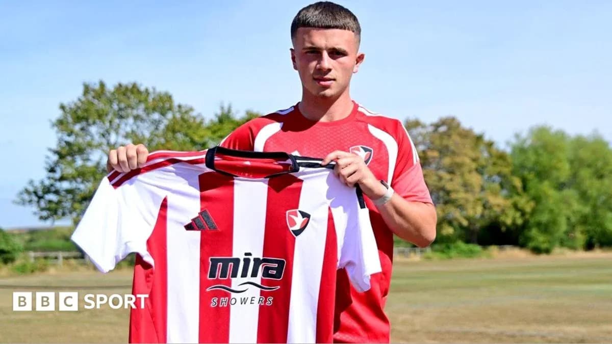 Player holding Cheltenham Town jersey during presentation Player holding Cheltenham Town jersey during presentation