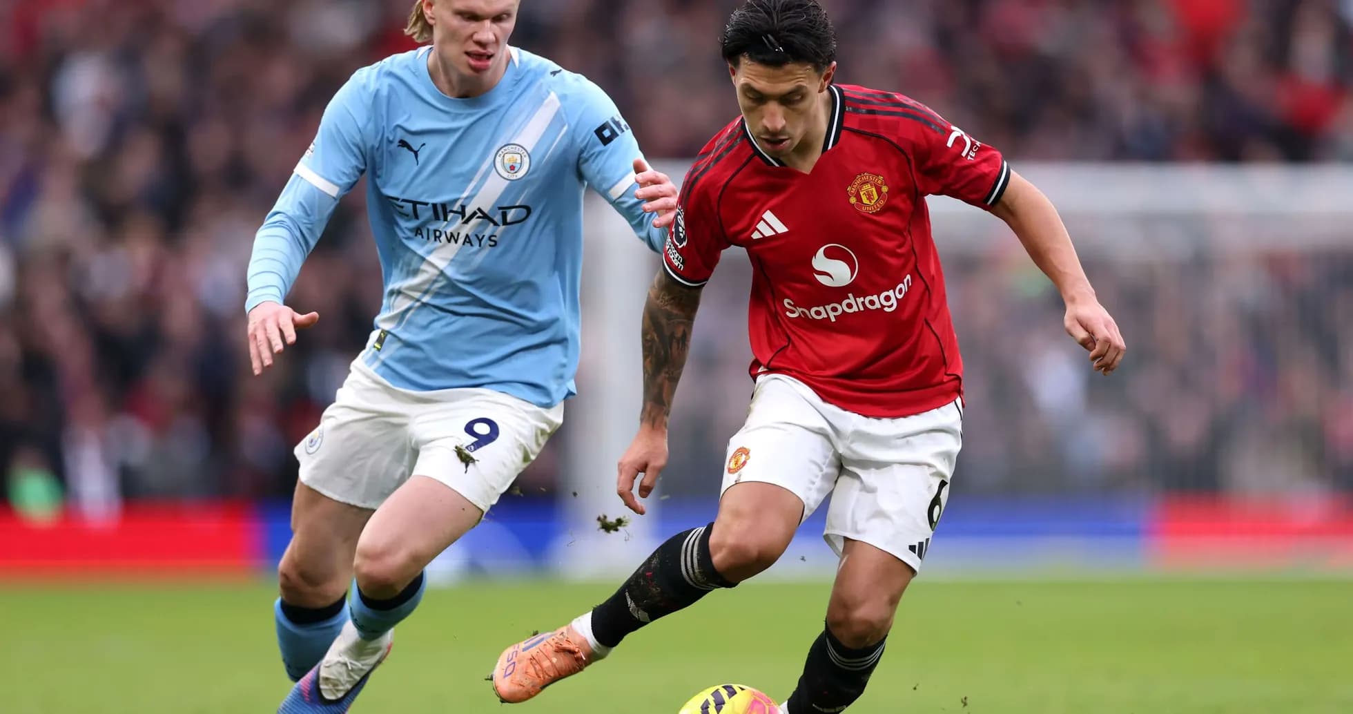 Manchester United player dribbling past Manchester City opponent Manchester United player dribbling past Manchester City opponent