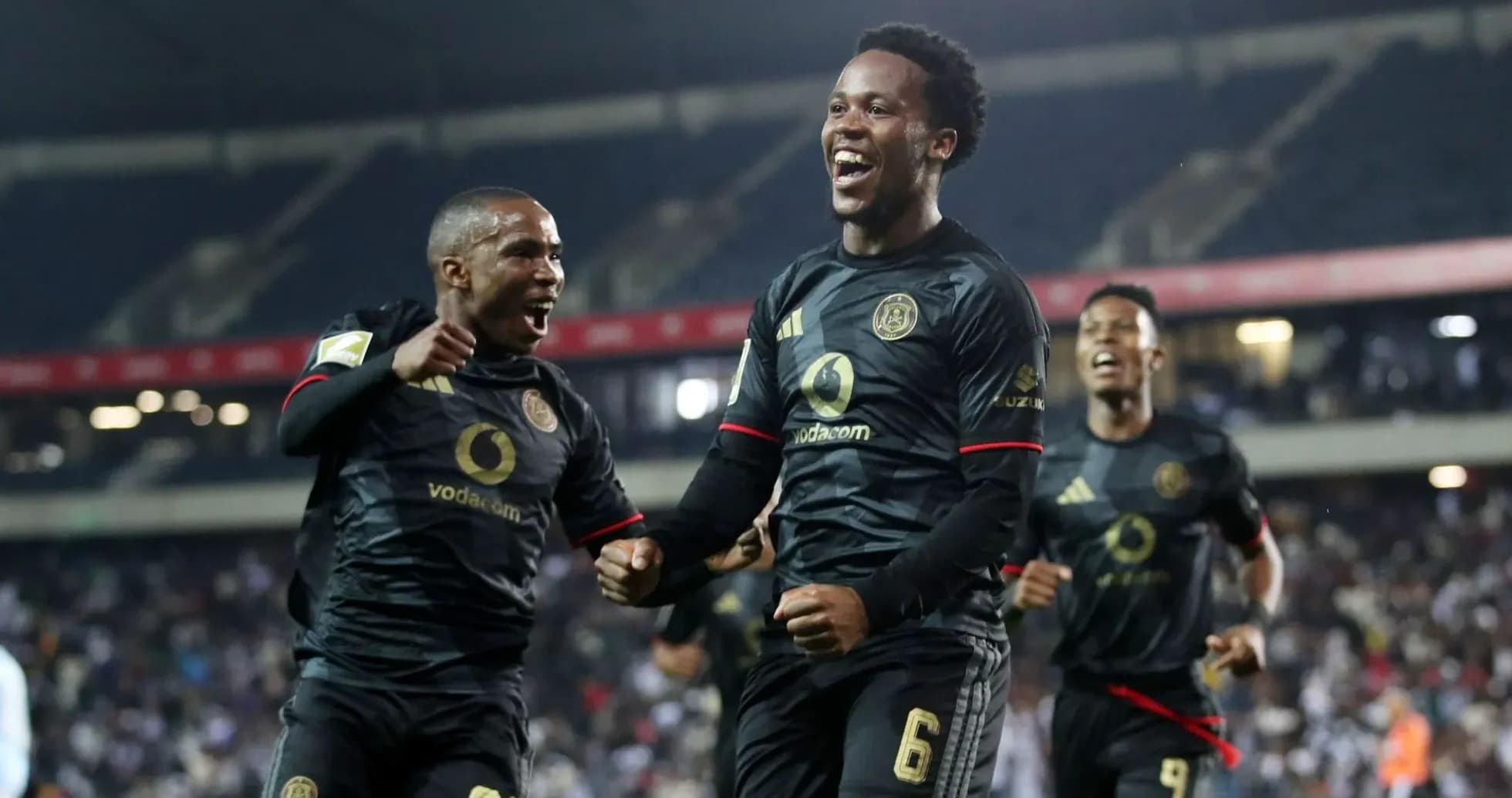 Players celebrating a goal in black jerseys Players celebrating a goal in black jerseys