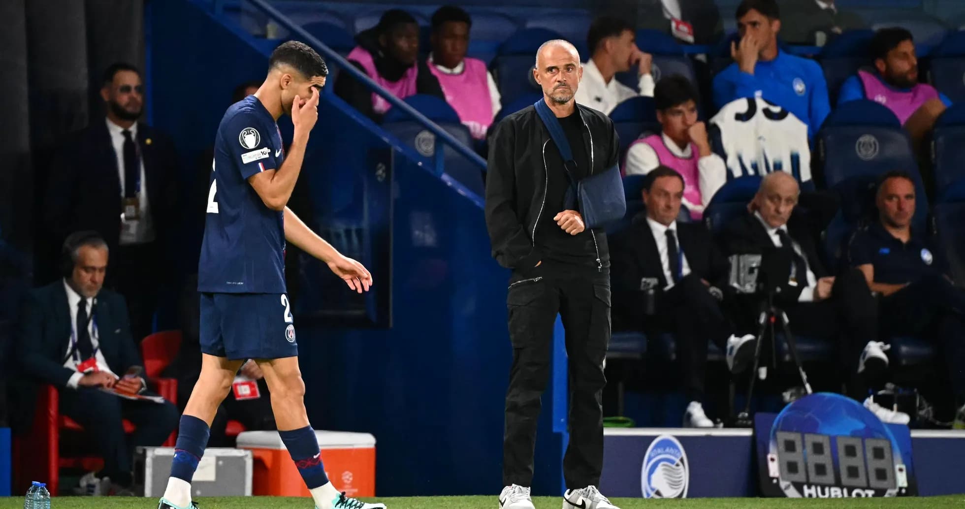 Player leaving the pitch with coach observing Player leaving the pitch with coach observing