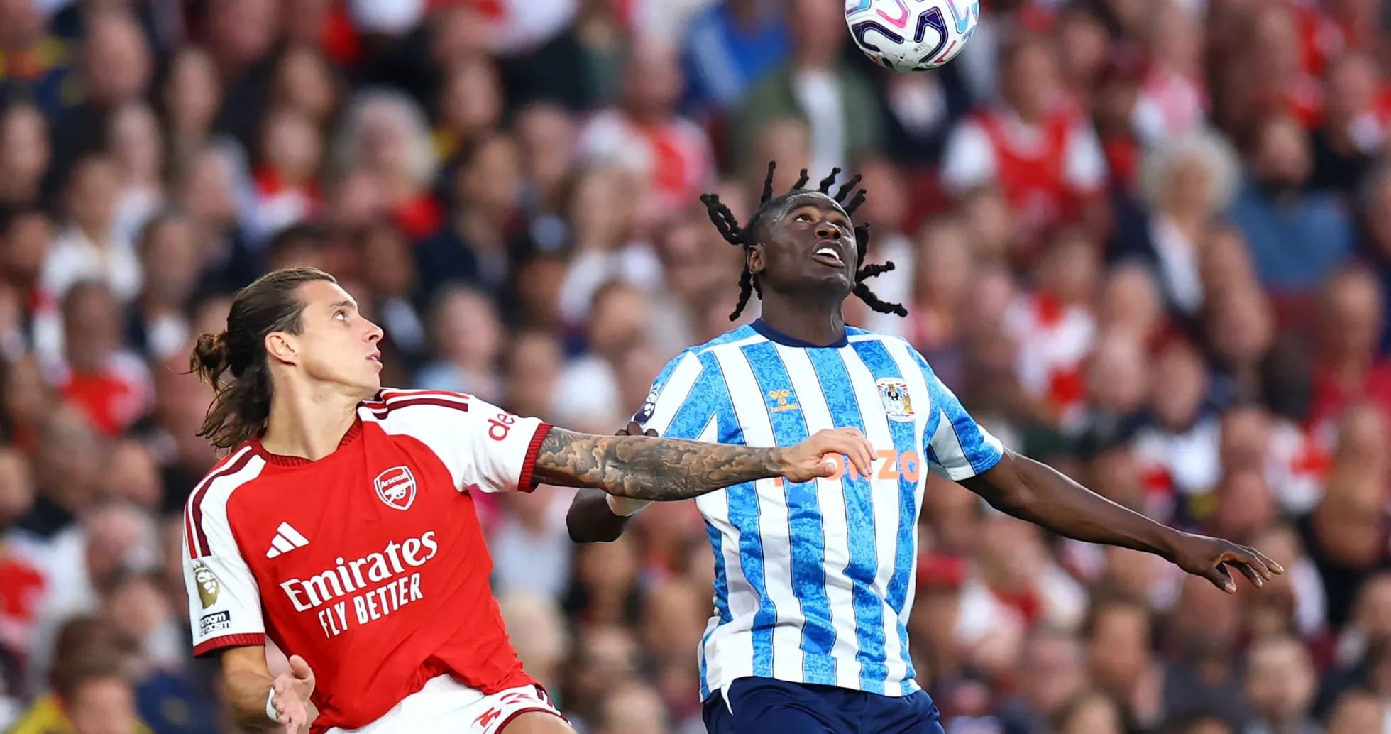 Arsenal player challenges Coventry player for ball Arsenal player challenges Coventry player for ball