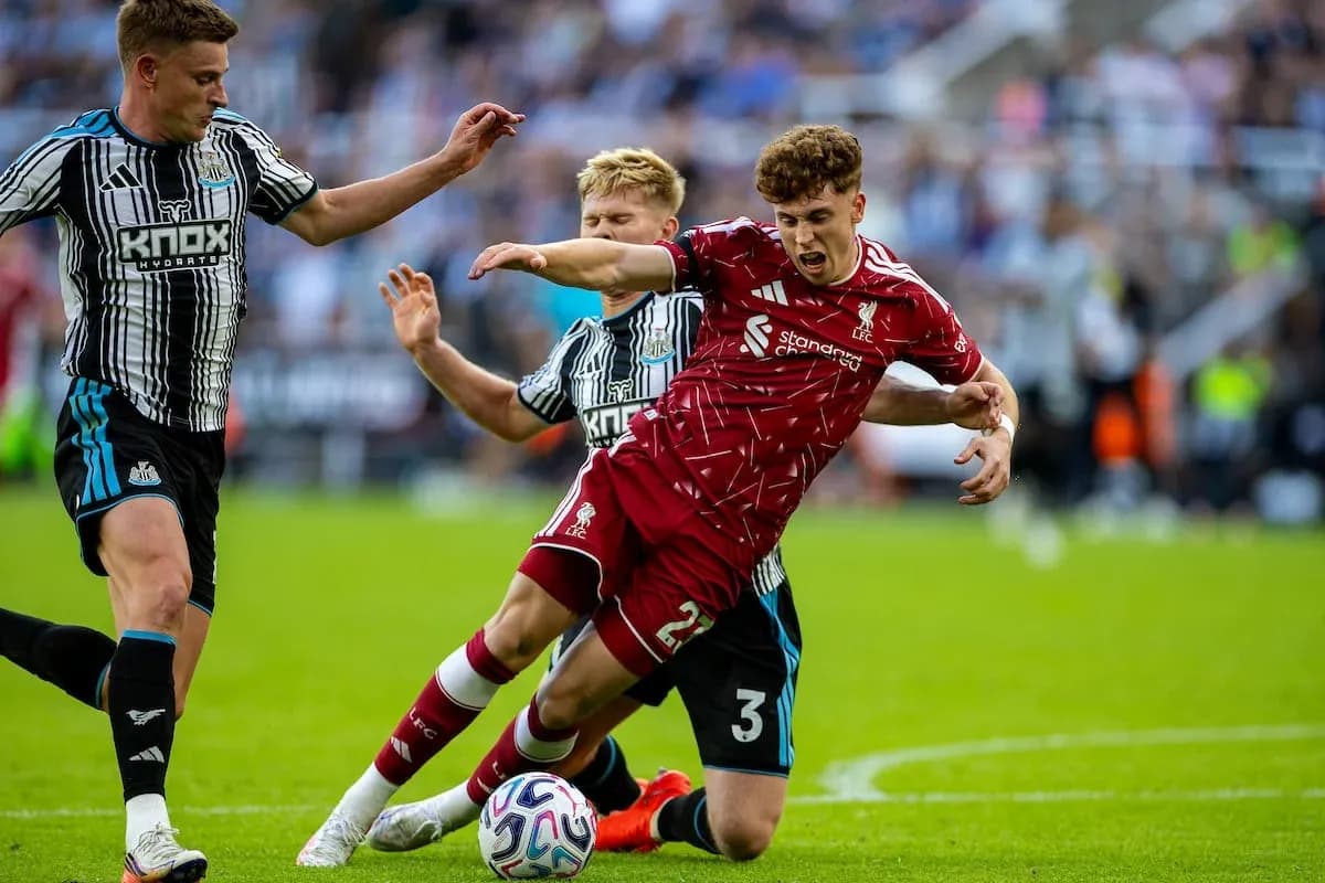Newcastle player challenges Liverpool player for the ball Newcastle player challenges Liverpool player for the ball