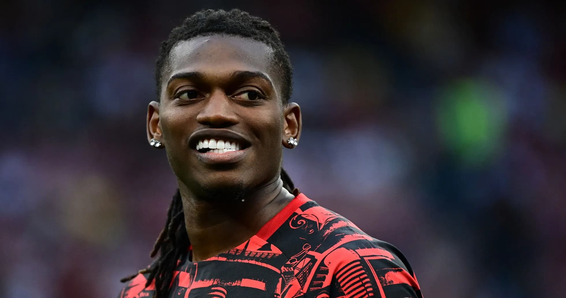 Player smiling in red patterned jersey during match Player smiling in red patterned jersey during match