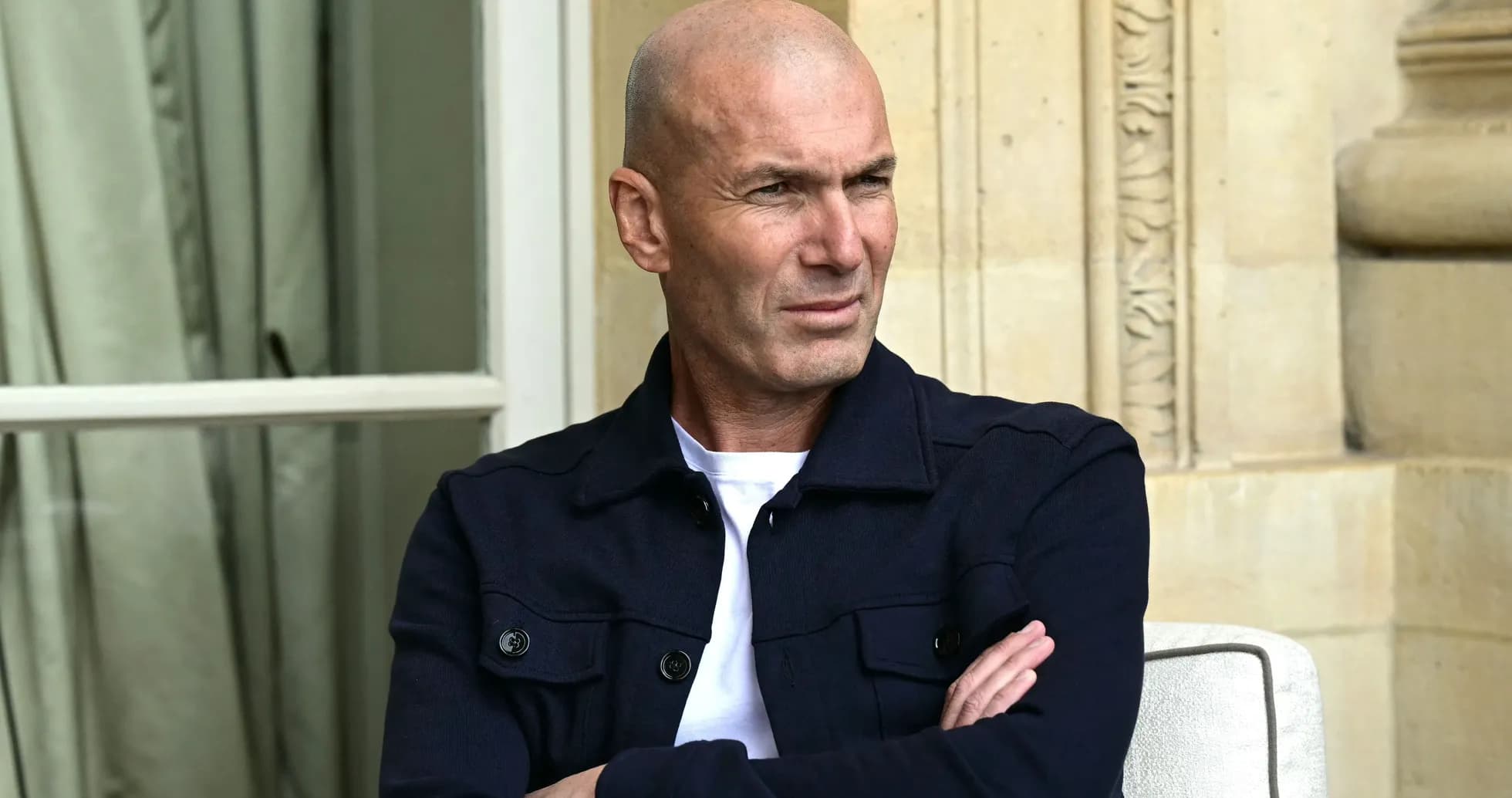 Man seated with arms crossed, looking thoughtfully Man seated with arms crossed, looking thoughtfully