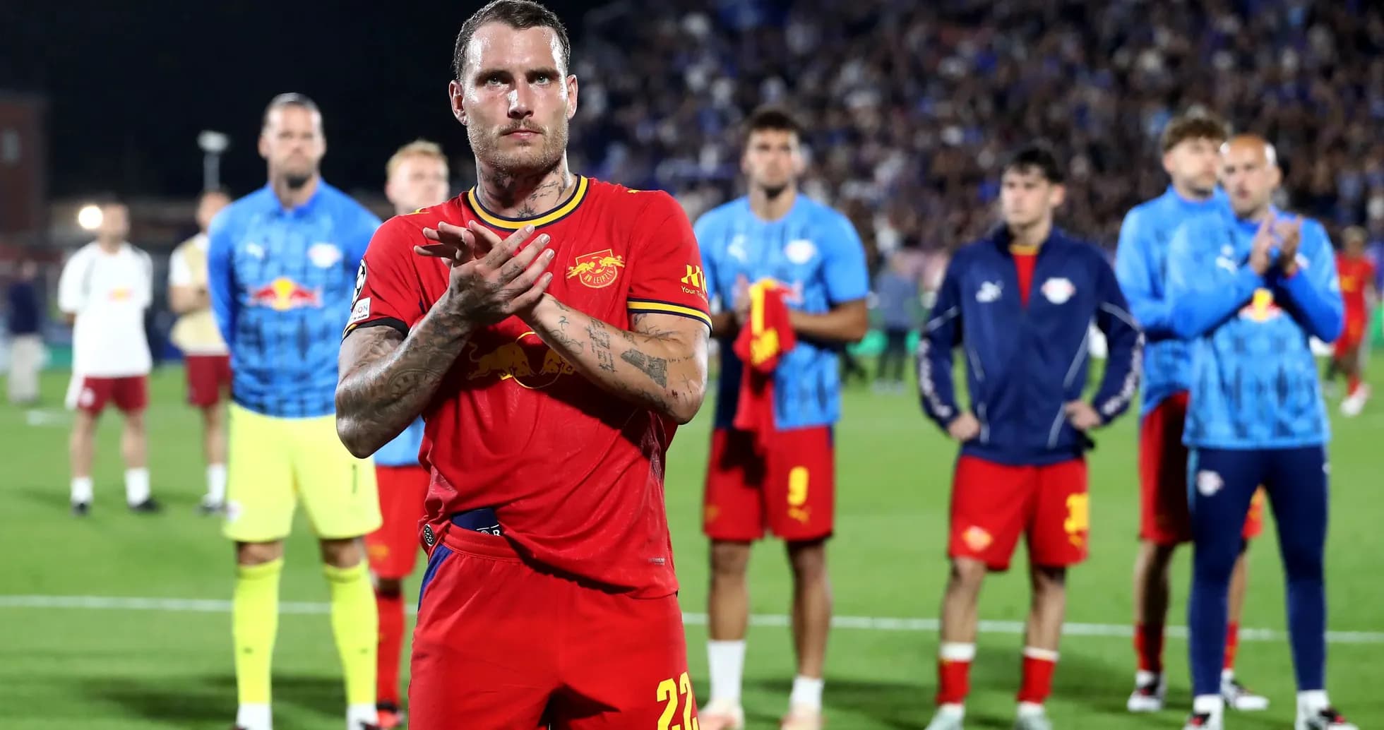 Player in red jersey applauding on the field Player in red jersey applauding on the field