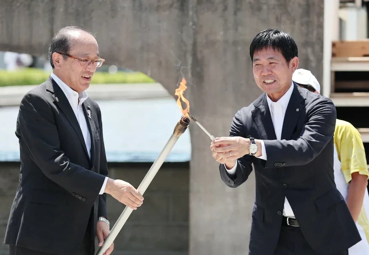 Two officials lighting a torch during ceremony Two officials lighting a torch during ceremony