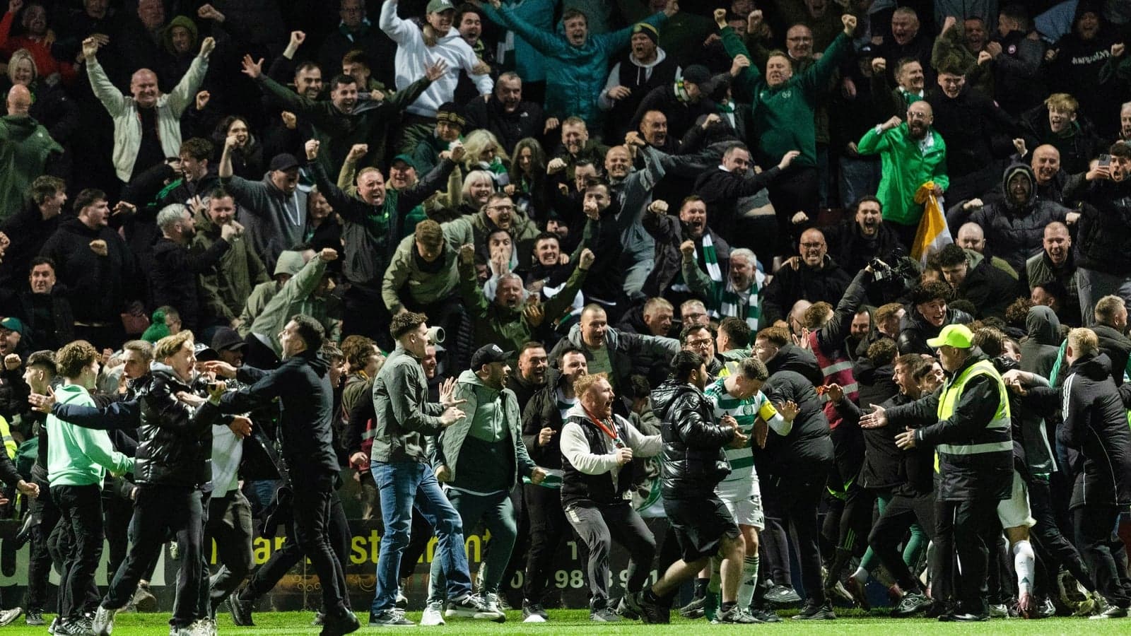 Fans celebrating on the pitch after a match Fans celebrating on the pitch after a match