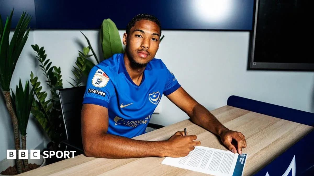 Player signing contract at a table with document Player signing contract at a table with document