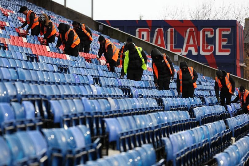 Workers cleaning seats in stadium stands Workers cleaning seats in stadium stands