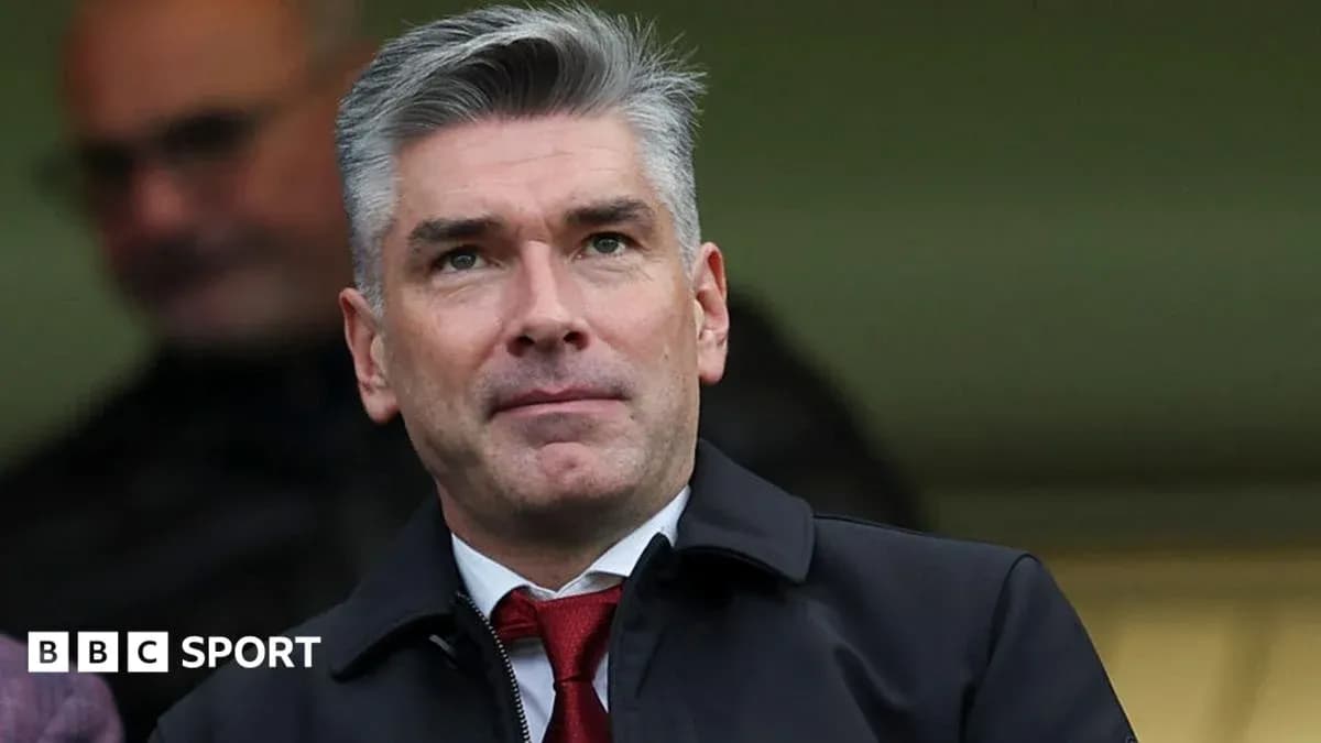 Man in a suit observing from the stands Man in a suit observing from the stands