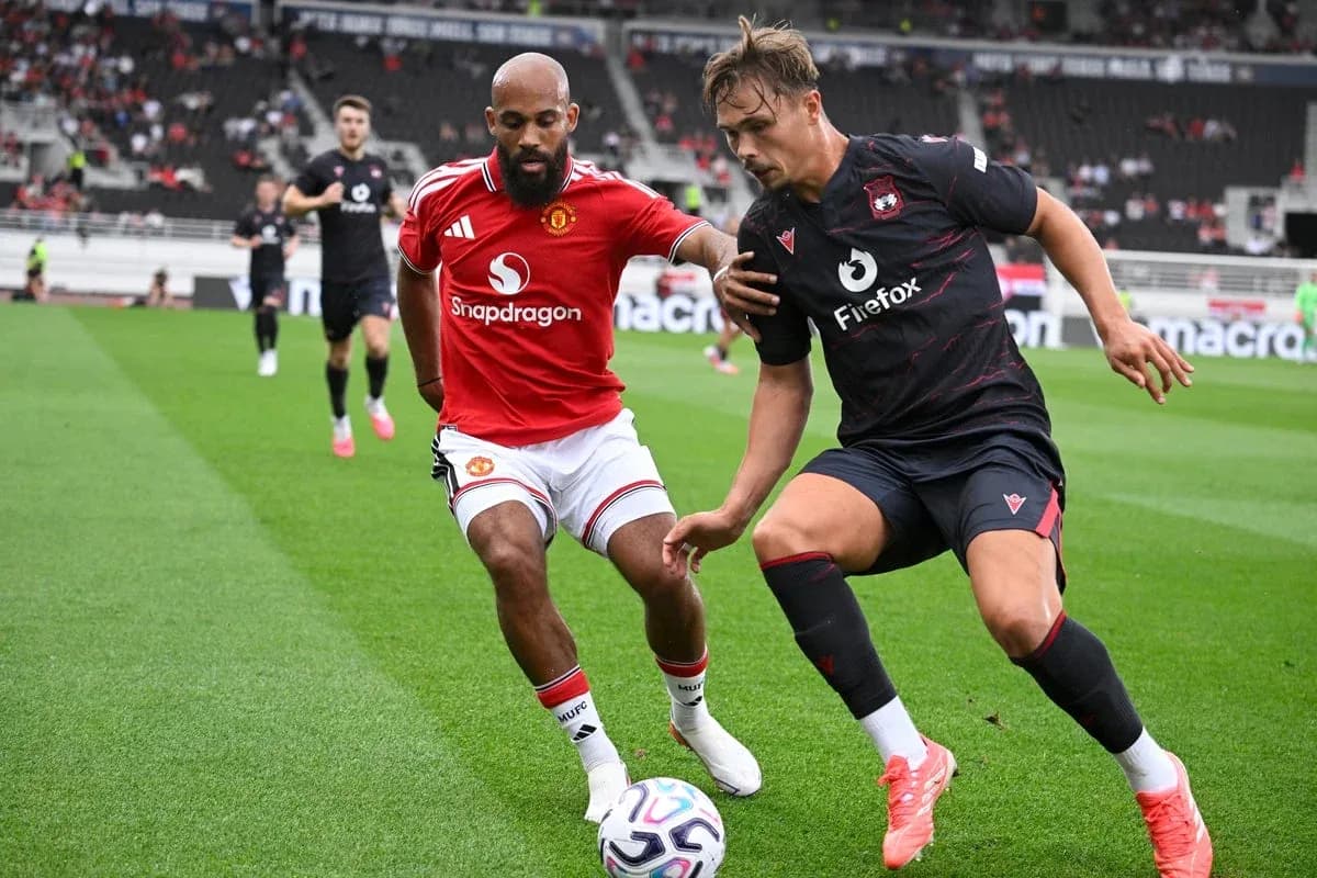 Two players competing for the ball on the pitch Two players competing for the ball on the pitch