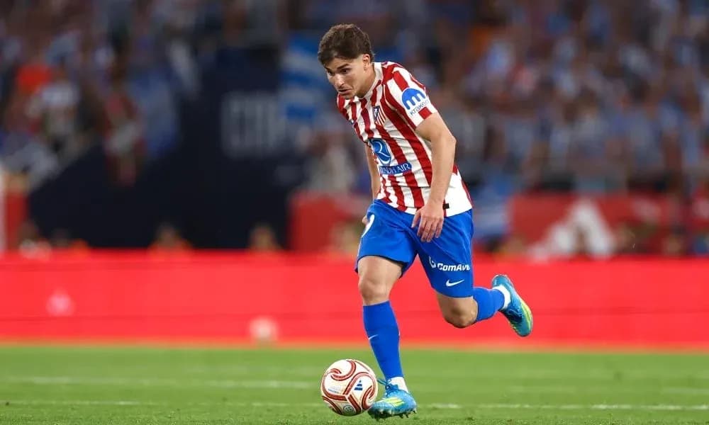 Player in Atlético Madrid kit dribbling the ball Player in Atlético Madrid kit dribbling the ball