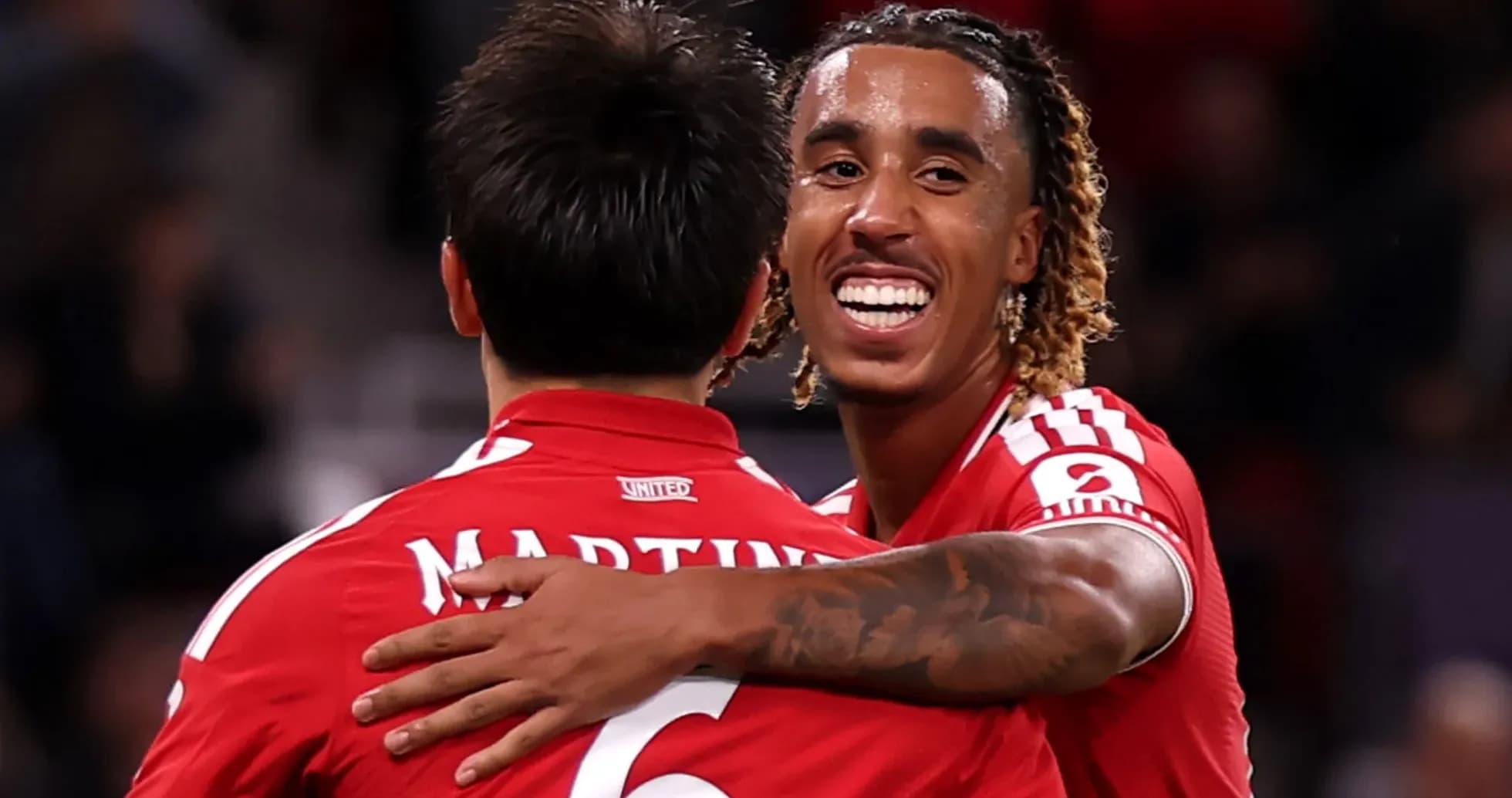 Two players celebrating in red jerseys during match Two players celebrating in red jerseys during match