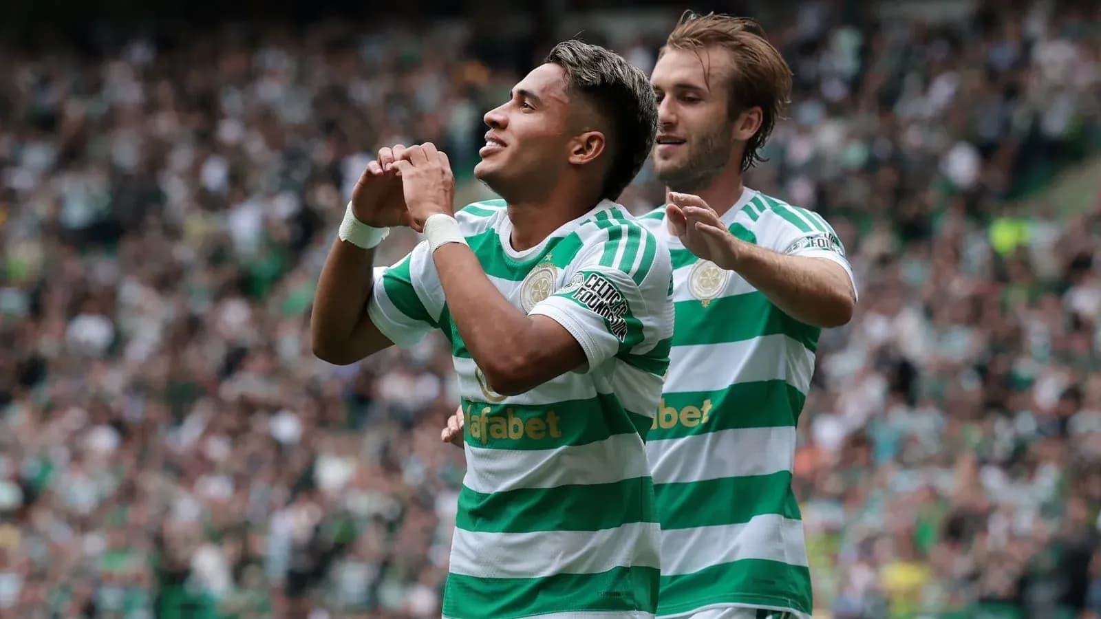 Celtic players celebrating a goal in stadium Celtic players celebrating a goal in stadium
