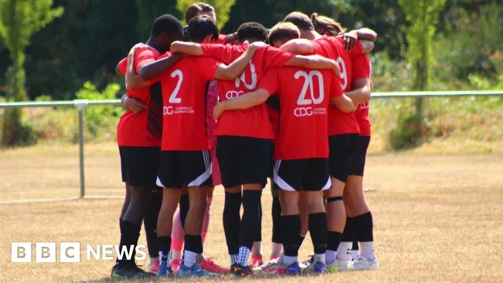 Team huddled together on the training field Team huddled together on the training field