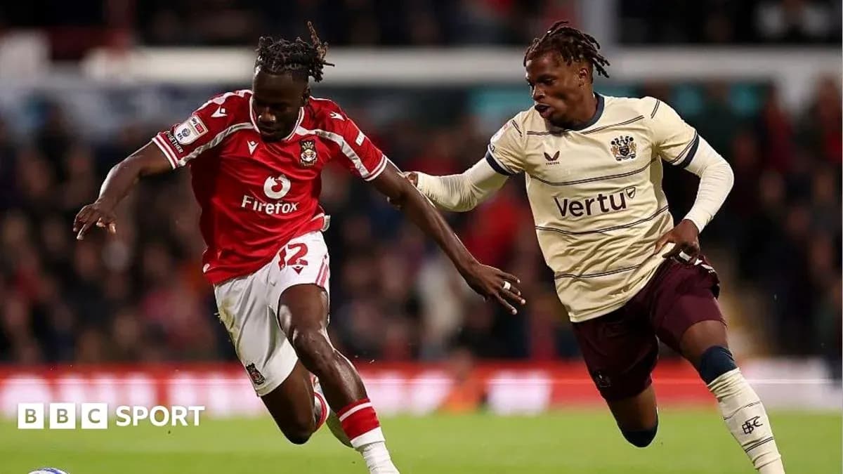 Player in red dribbling past opponent in beige kit Player in red dribbling past opponent in beige kit
