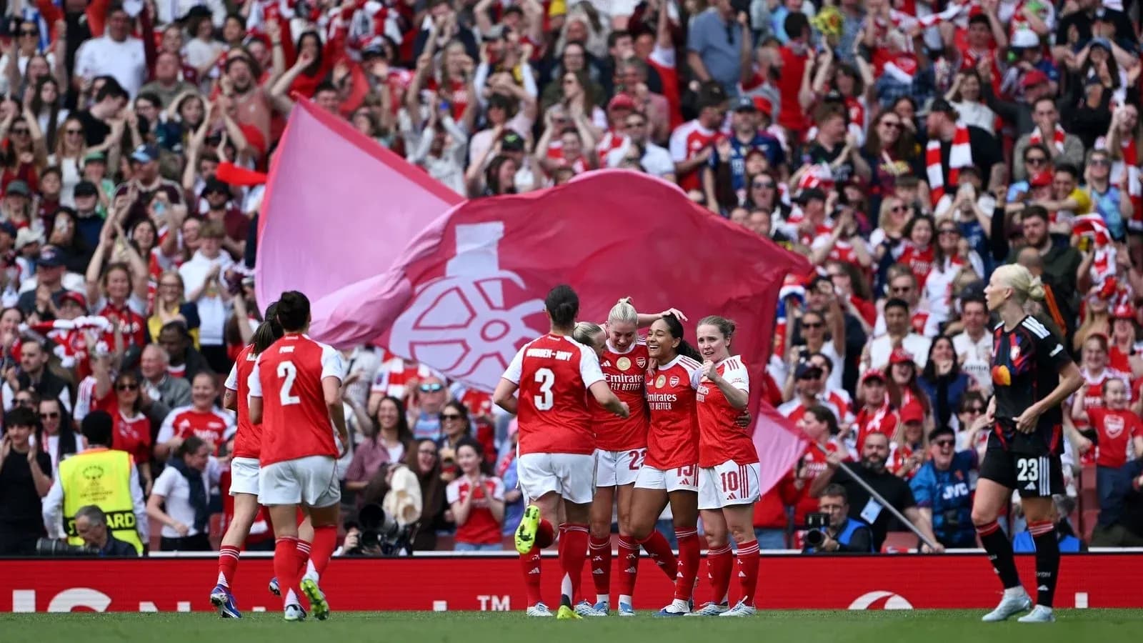 Arsenal women celebrating a goal with fans cheering Arsenal women celebrating a goal with fans cheering