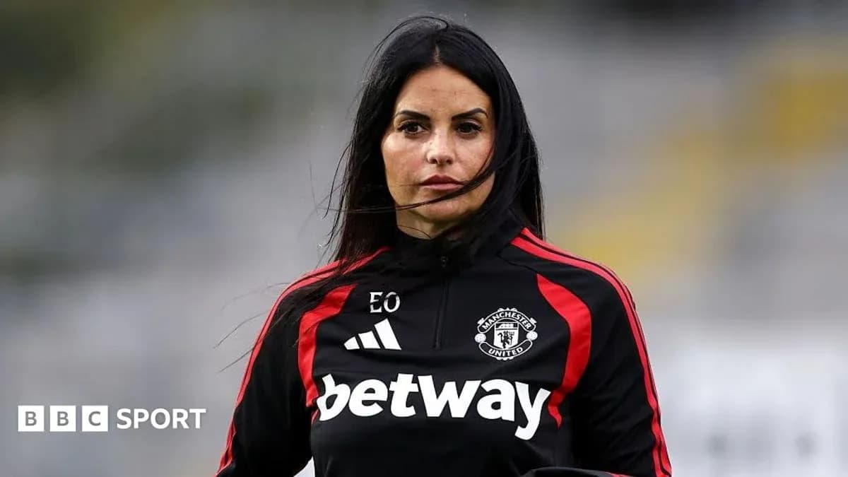 Woman in Manchester United training gear on pitch Woman in Manchester United training gear on pitch
