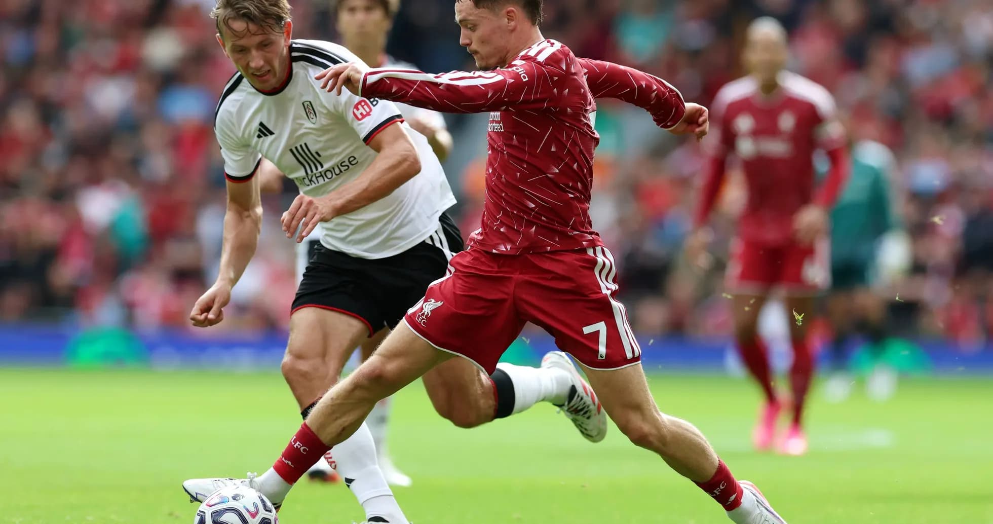 Liverpool player dribbling past Fulham defender Liverpool player dribbling past Fulham defender