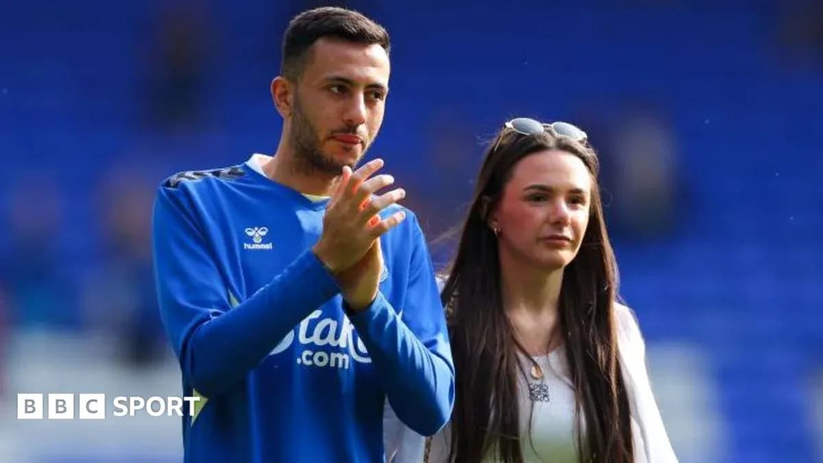 Player and companion walking on pitch after match Player and companion walking on pitch after match