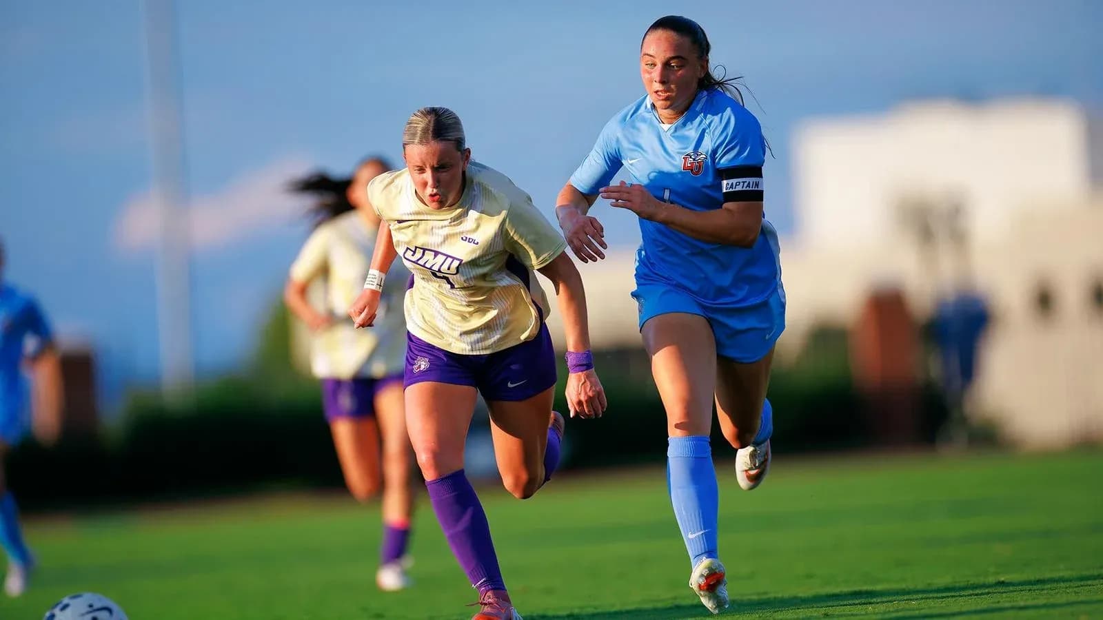 Two soccer players racing for the ball on field Two soccer players racing for the ball on field