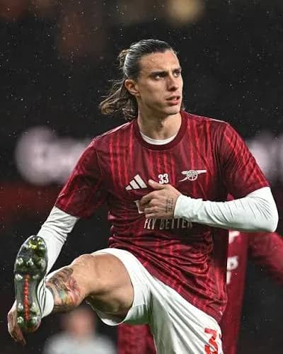 Player stretching during warm-up in red kit Player stretching during warm-up in red kit