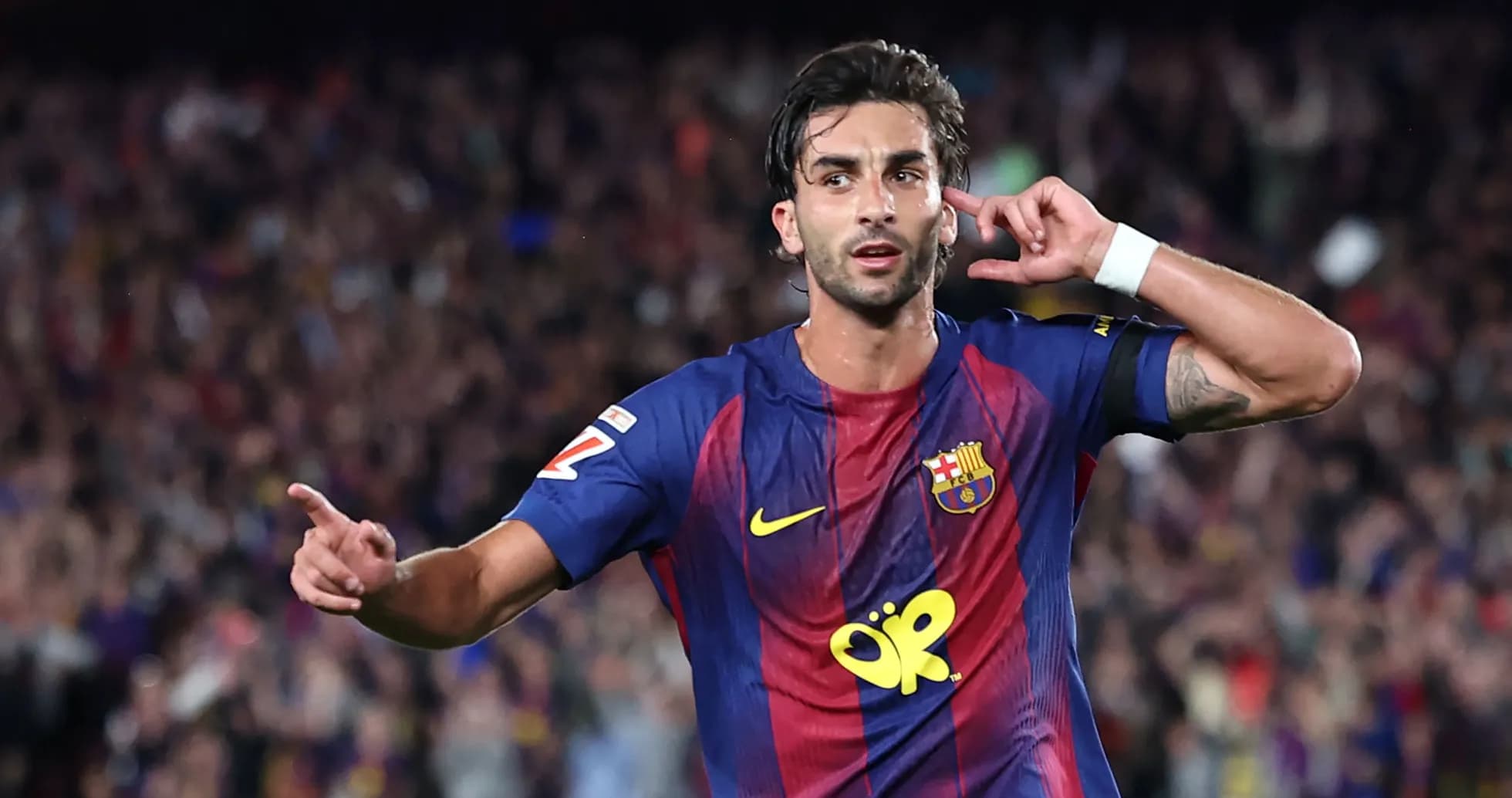 Player celebrating goal with crowd in background Player celebrating goal with crowd in background