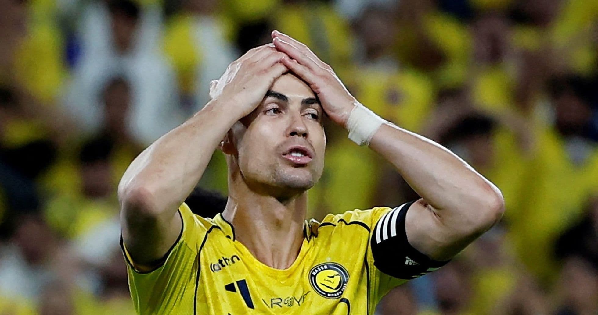 Player in yellow jersey holding head in frustration Player in yellow jersey holding head in frustration