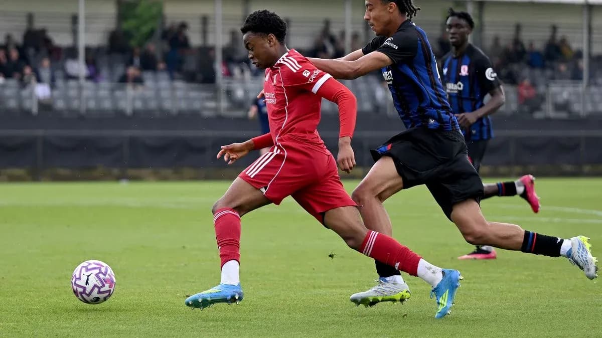 Player in red dribbling past opponent in blue Player in red dribbling past opponent in blue