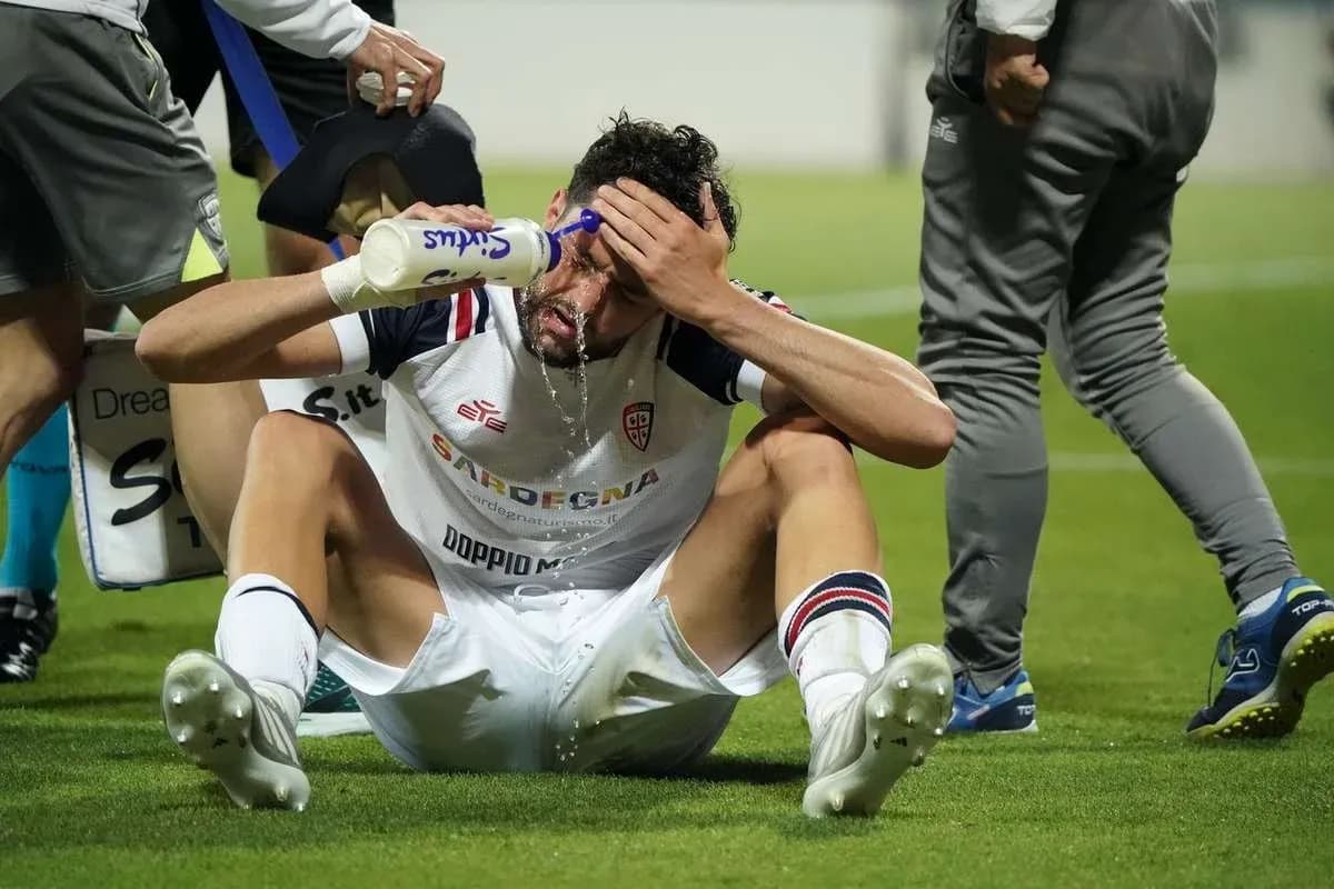 Player sitting on the ground pouring water on face Player sitting on the ground pouring water on face