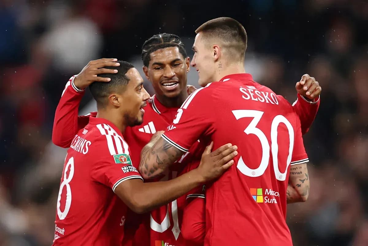 Three players celebrating a goal in red jerseys Three players celebrating a goal in red jerseys