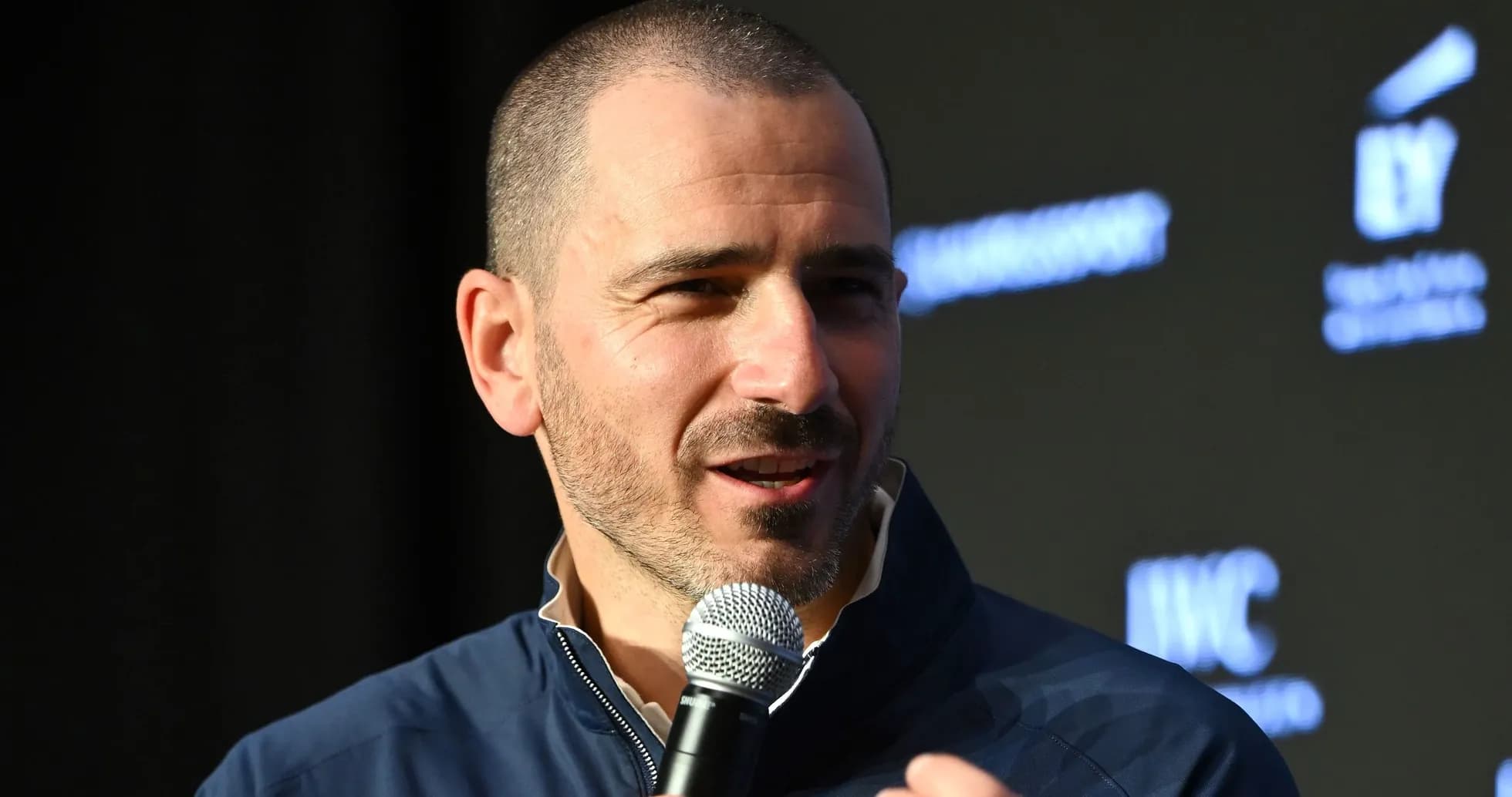 Person speaking into a microphone at event Person speaking into a microphone at event