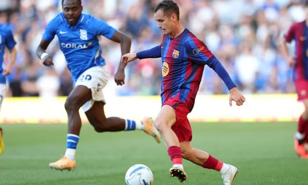 Barcelona player dribbling past Birmingham defender during match Barcelona player dribbling past Birmingham defender during match