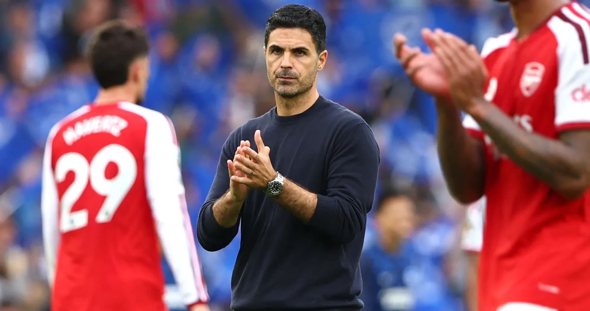 Arsenal manager clapping with players in background Arsenal manager clapping with players in background