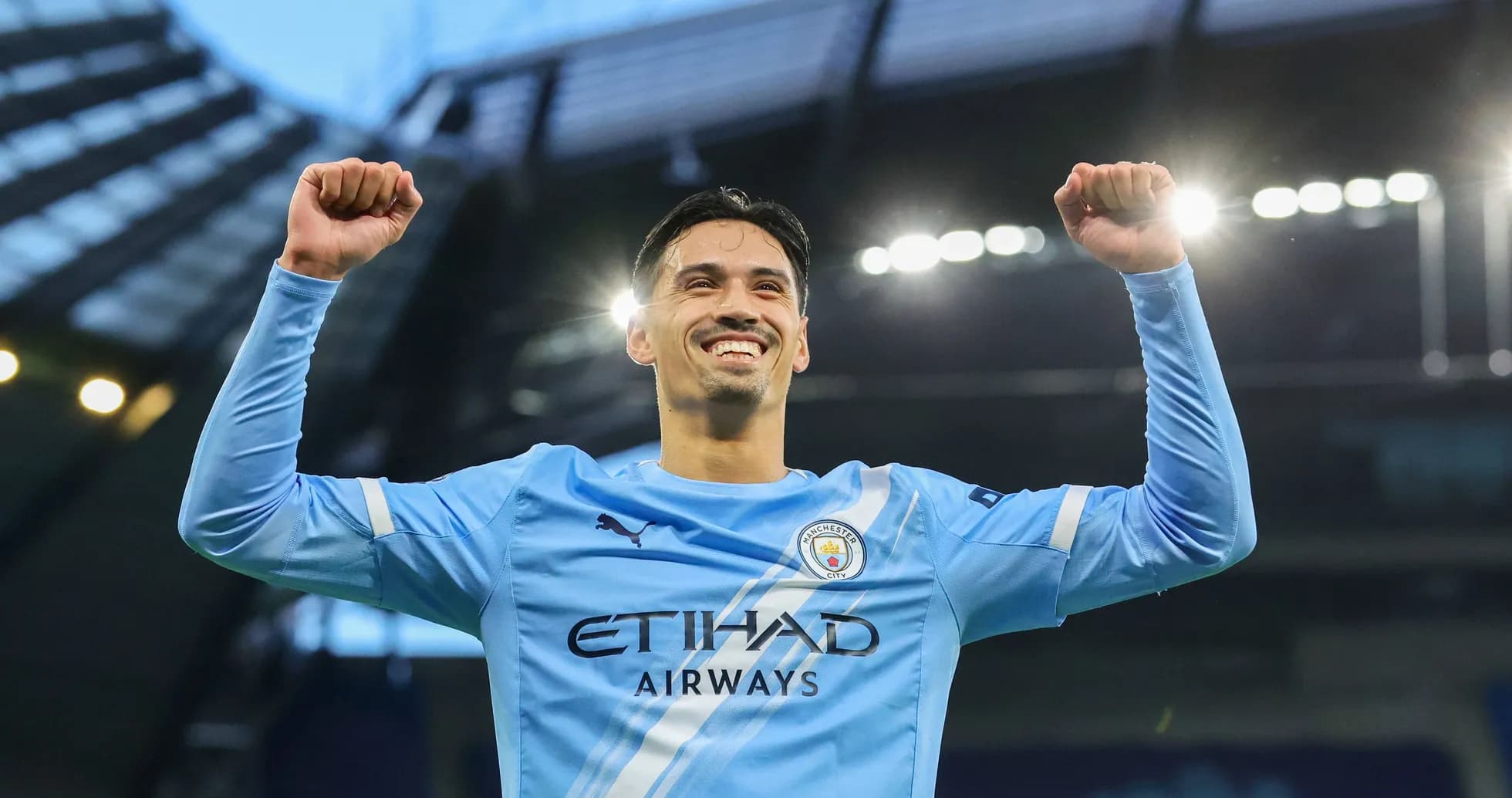 Player celebrating with raised arms at stadium Player celebrating with raised arms at stadium